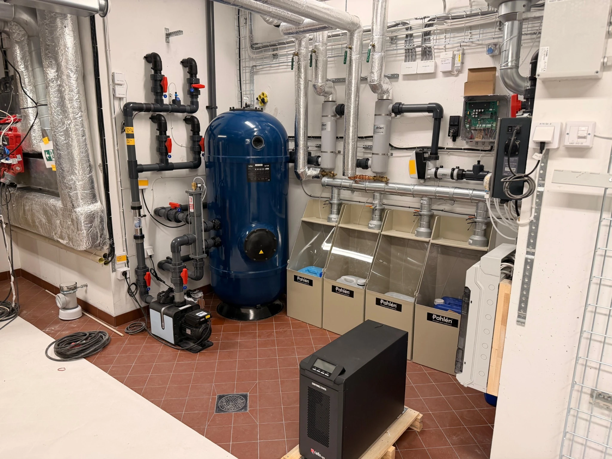 A Poolworks technical installation with a blue filter, pumps, heating equipment and neatly arranged pipework