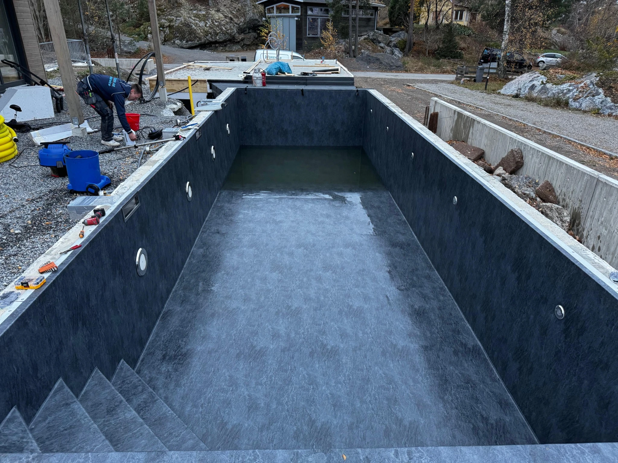 A Poolworks pool under construction, with a worker fitting details around the shell
